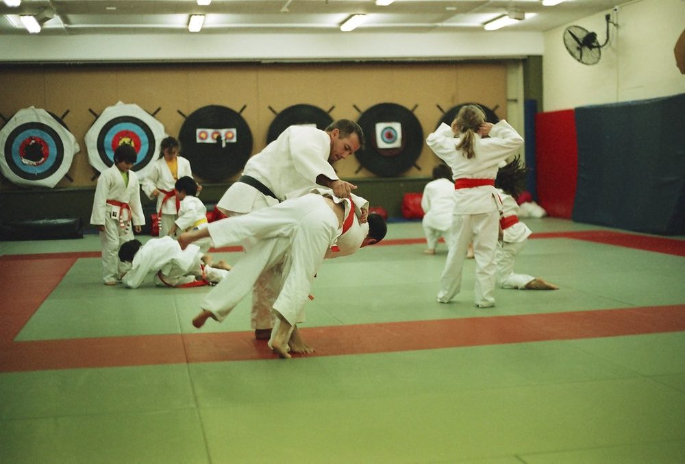 Aula de luta agarrada para crianças de kimono branco no tatame