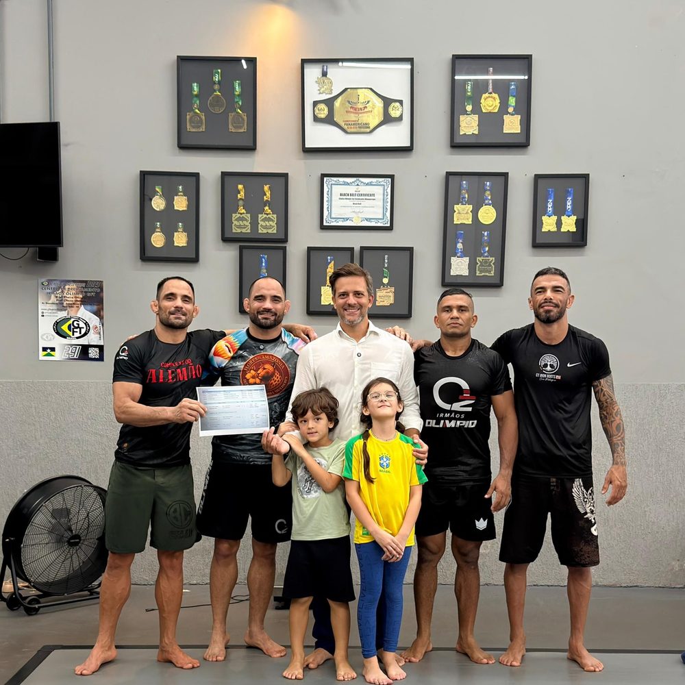 Alunos e professores no tatame do CT, diante da parede de medalhas e do cinturão Panamericano